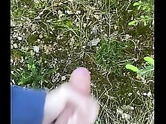 Young boy strokes his cock in forest